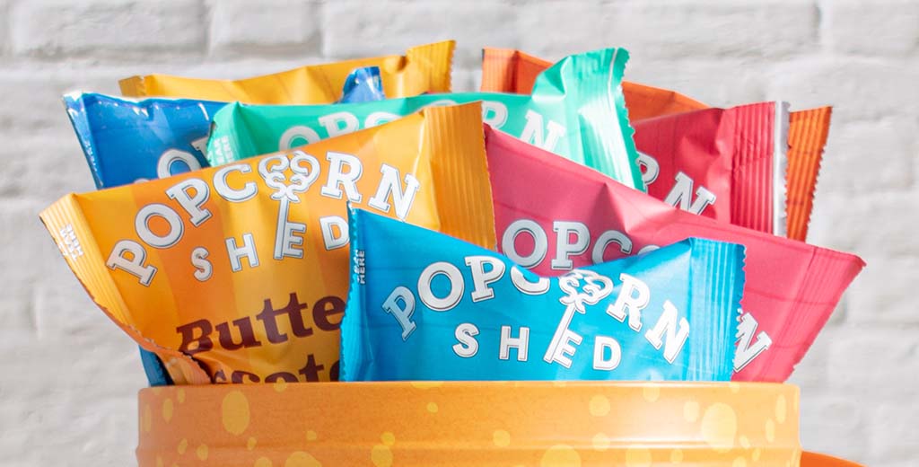 A close up of gourmet popcorn snack packs in Popcorn Shed's flavour selection gift tin